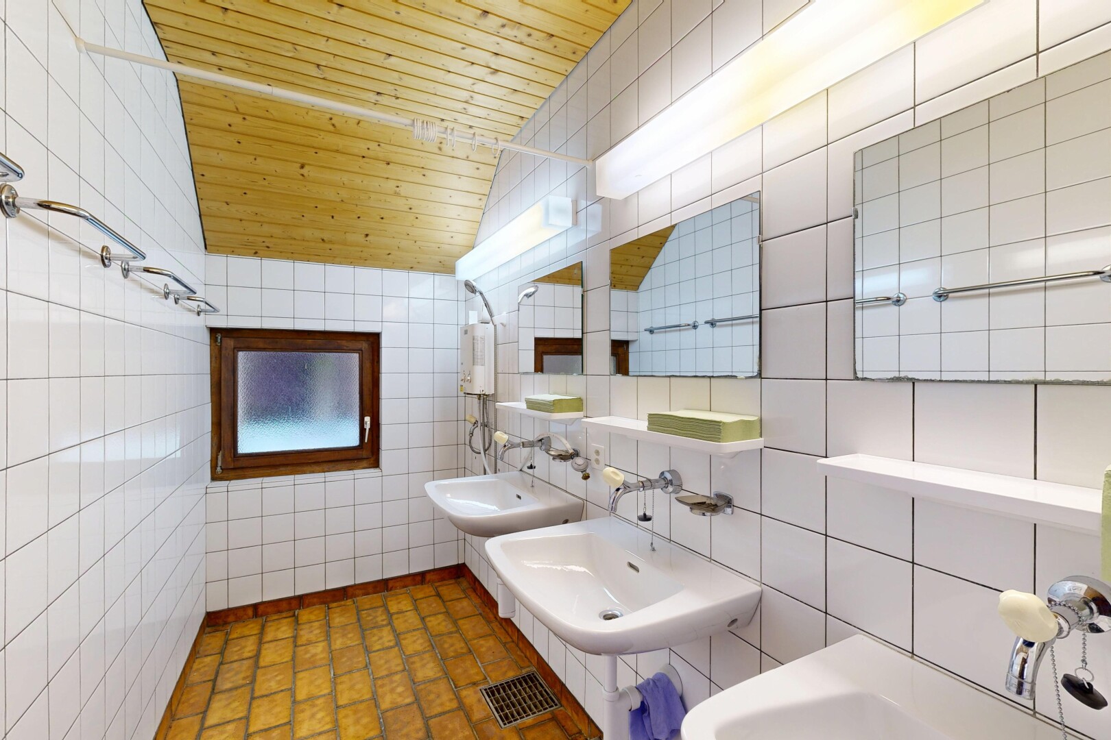 salle de bains avec tile wall, mur en carrelage, deux éviers simples, miroir, et inside property