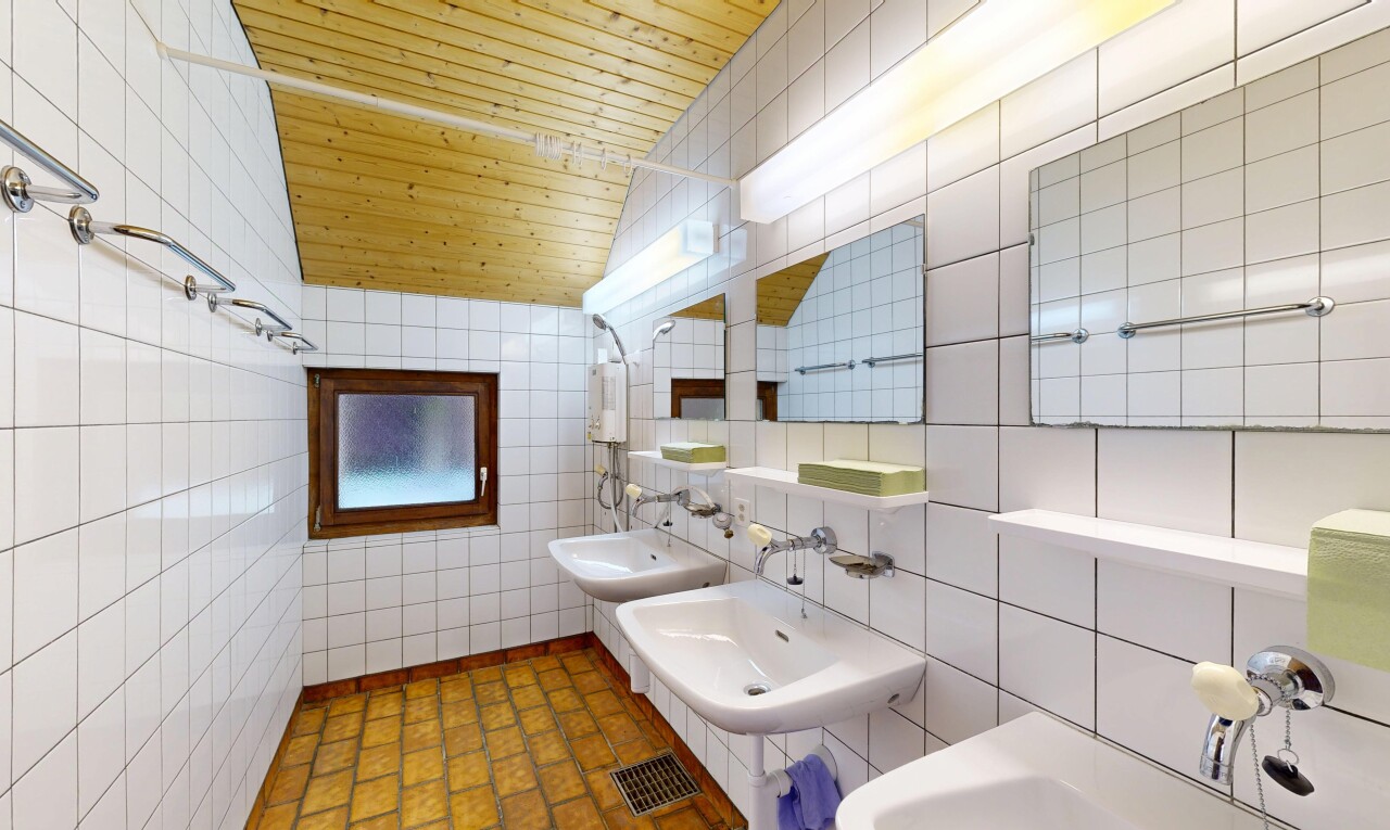 salle de bains avec tile wall, mur en carrelage, deux éviers simples, miroir, et inside property