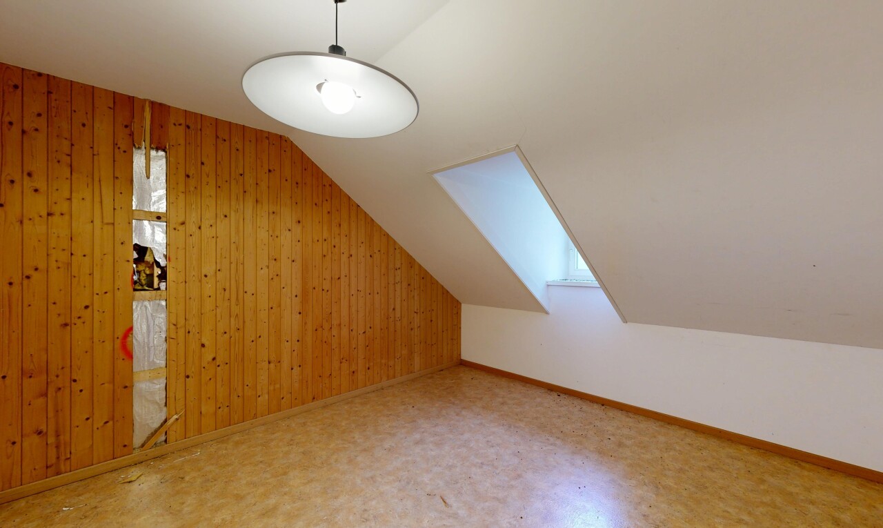 pièce vide avec vaulted ceiling, plafond voûté, wood wall, mur en bois, et inside property