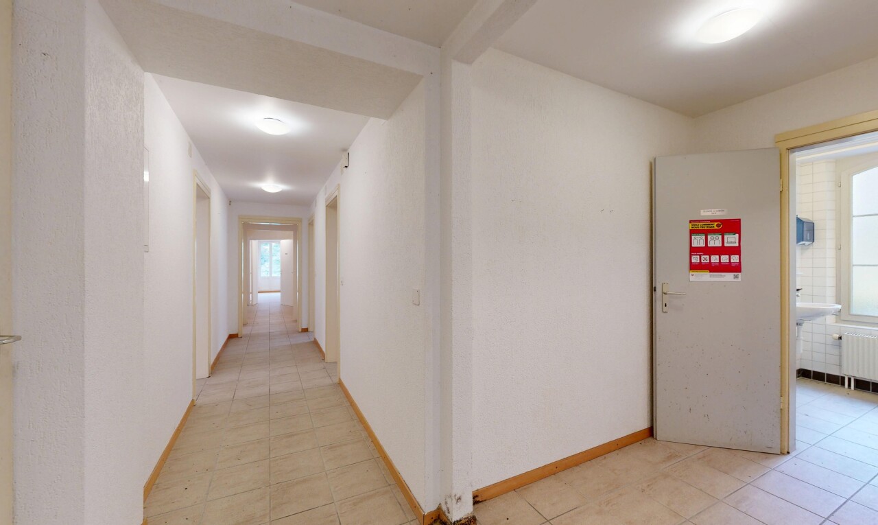 couloir avec inside property, light floor, baseboards wall, plinthes murales, et tile floor