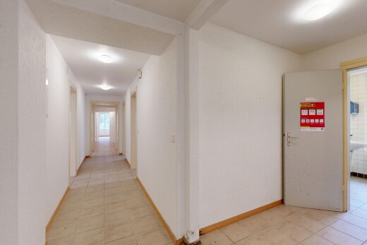 couloir avec inside property, light floor, baseboards wall, plinthes murales, et tile floor