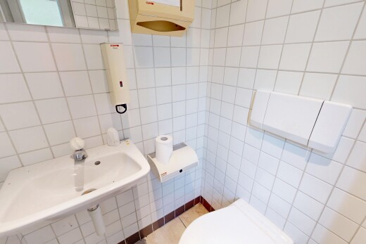 salle de bains avec toilette, tile wall, mur en carrelage, inside property, et évier