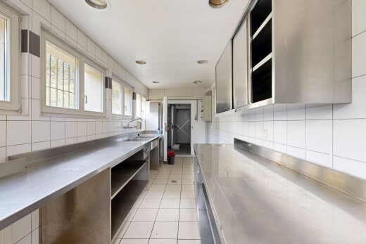 cuisine avec plans de travail en acier inoxydable, stainless steel countertops, light floor, inside property, et lumière naturelle