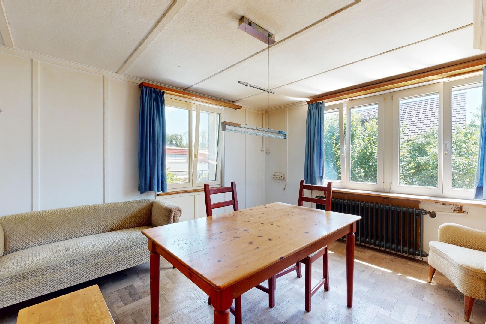 wohn- / esszimmer mit natürliches licht, holzfußboden, wood finish floor, kühler, und manufactured wall