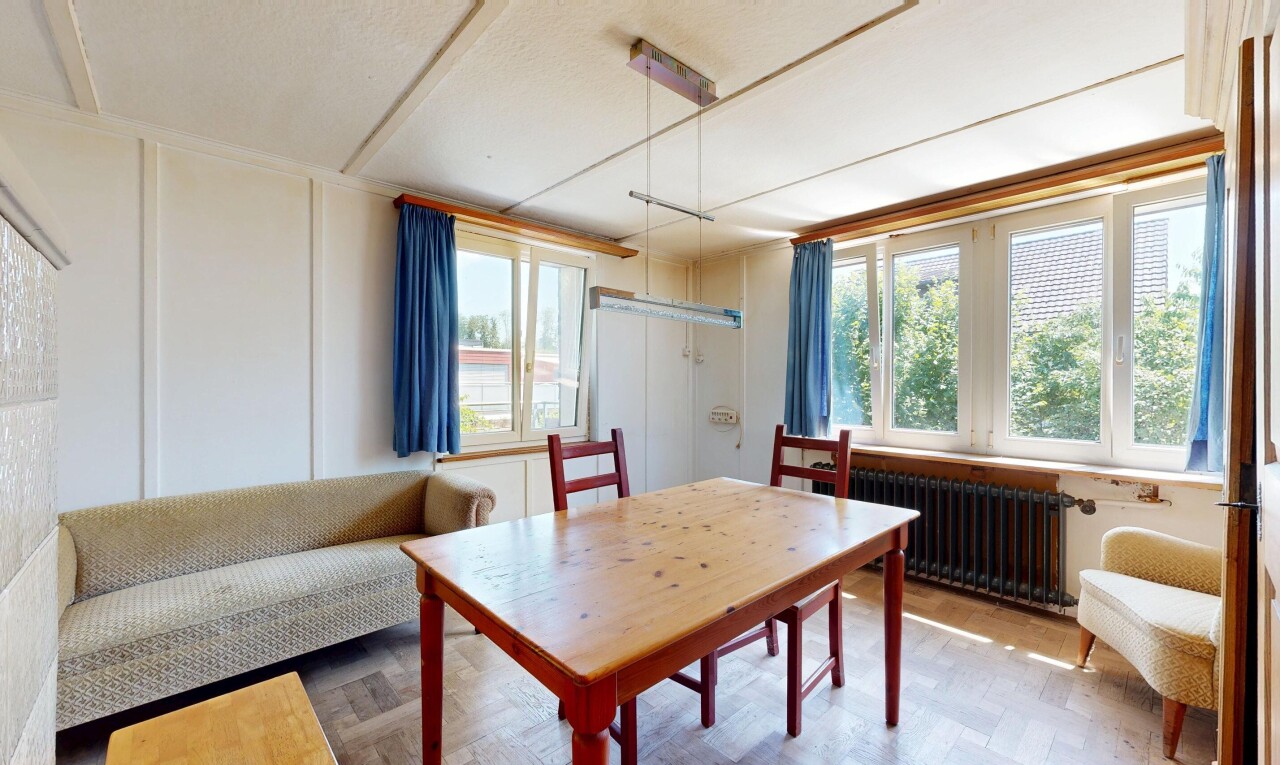 wohn- / esszimmer mit natürliches licht, holzfußboden, wood finish floor, kühler, und manufactured wall