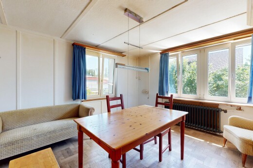 wohn- / esszimmer mit natürliches licht, holzfußboden, wood finish floor, kühler, und manufactured wall