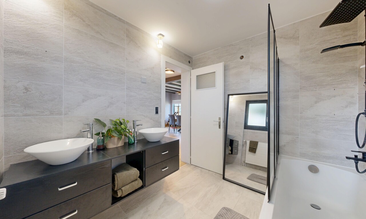 salle de bains avec tile wall, mur en carrelage, salle de bain complète, double vasque, et miroir