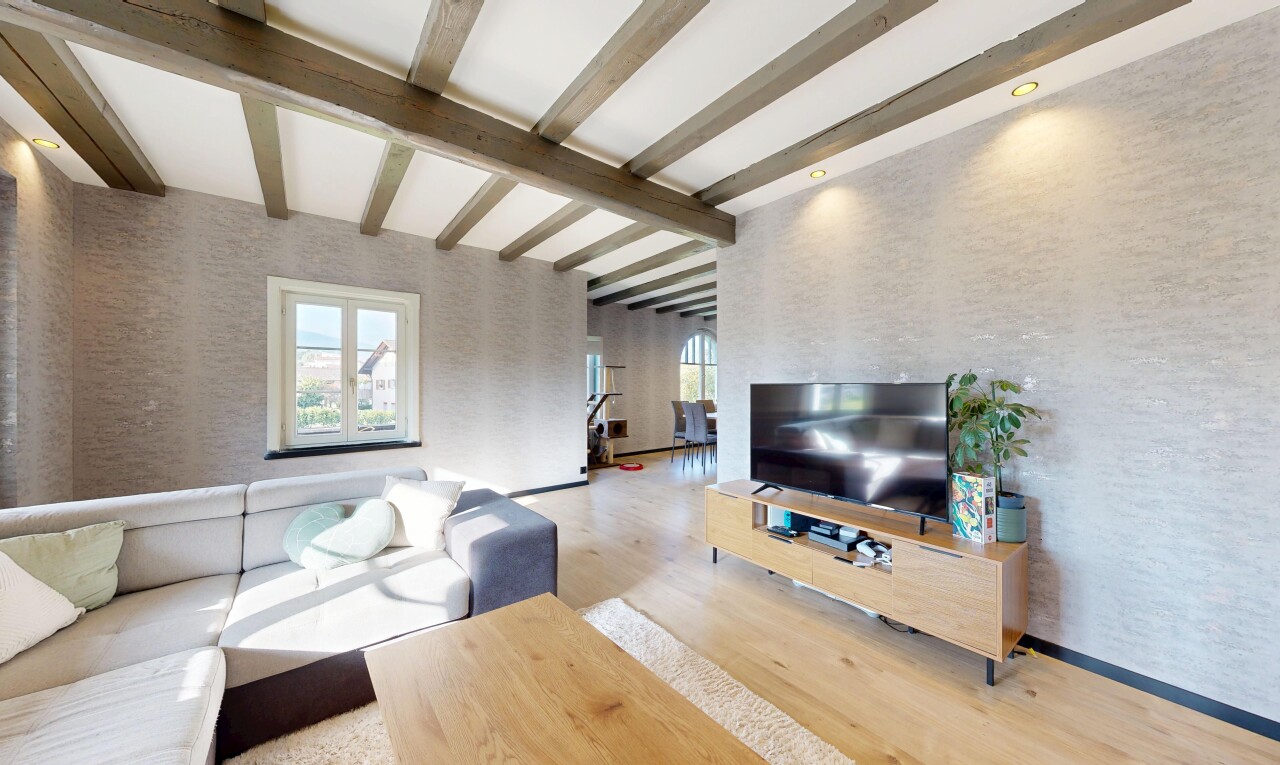 salon avec télévision, wood finish floor, sol en finition bois, inside property, et beamed ceiling