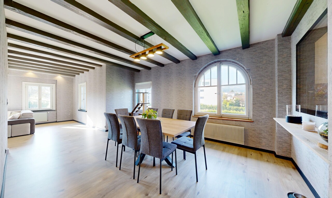 salle à manger avec beamed ceiling, plafond à poutres, wood finish floor, sol en finition bois, et natural light