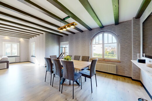 salle à manger avec beamed ceiling, plafond à poutres, wood finish floor, sol en finition bois, et natural light