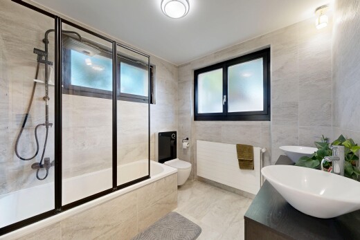 salle de bains avec mur en carrelage, tile wall, douche-bain combinés, double vasque, et salle de bain complète