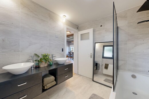 salle de bains avec tile wall, mur en carrelage, salle de bain complète, double vasque, et miroir