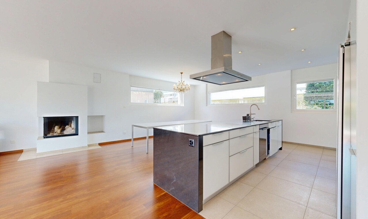 kitchen featuring island range hood, white cabinetry, light countertops, a glass covered fireplace, and open floor plan