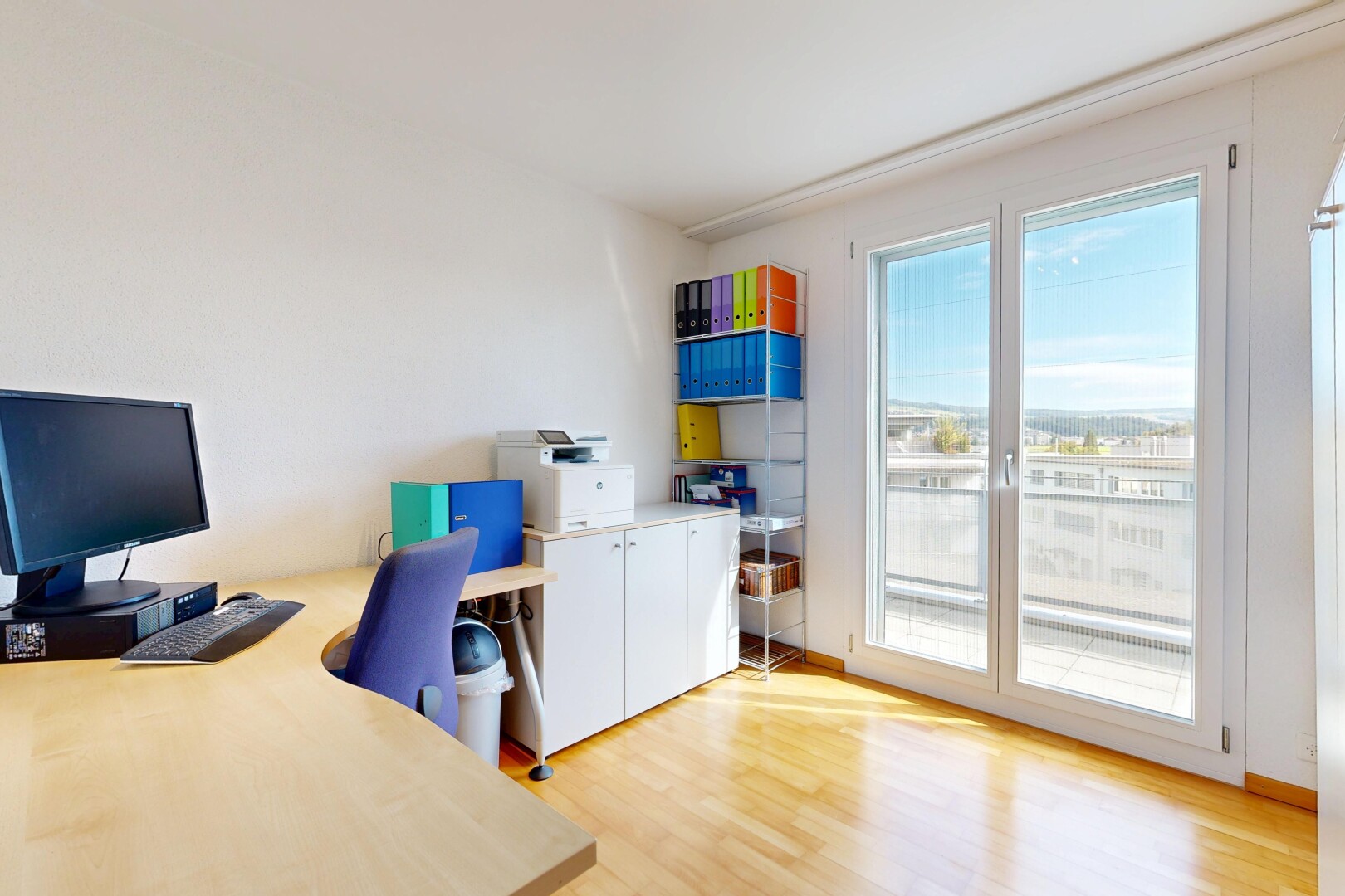 büro mit bürobereich, natürliches licht, natural light, fernseher, und holzfußboden
