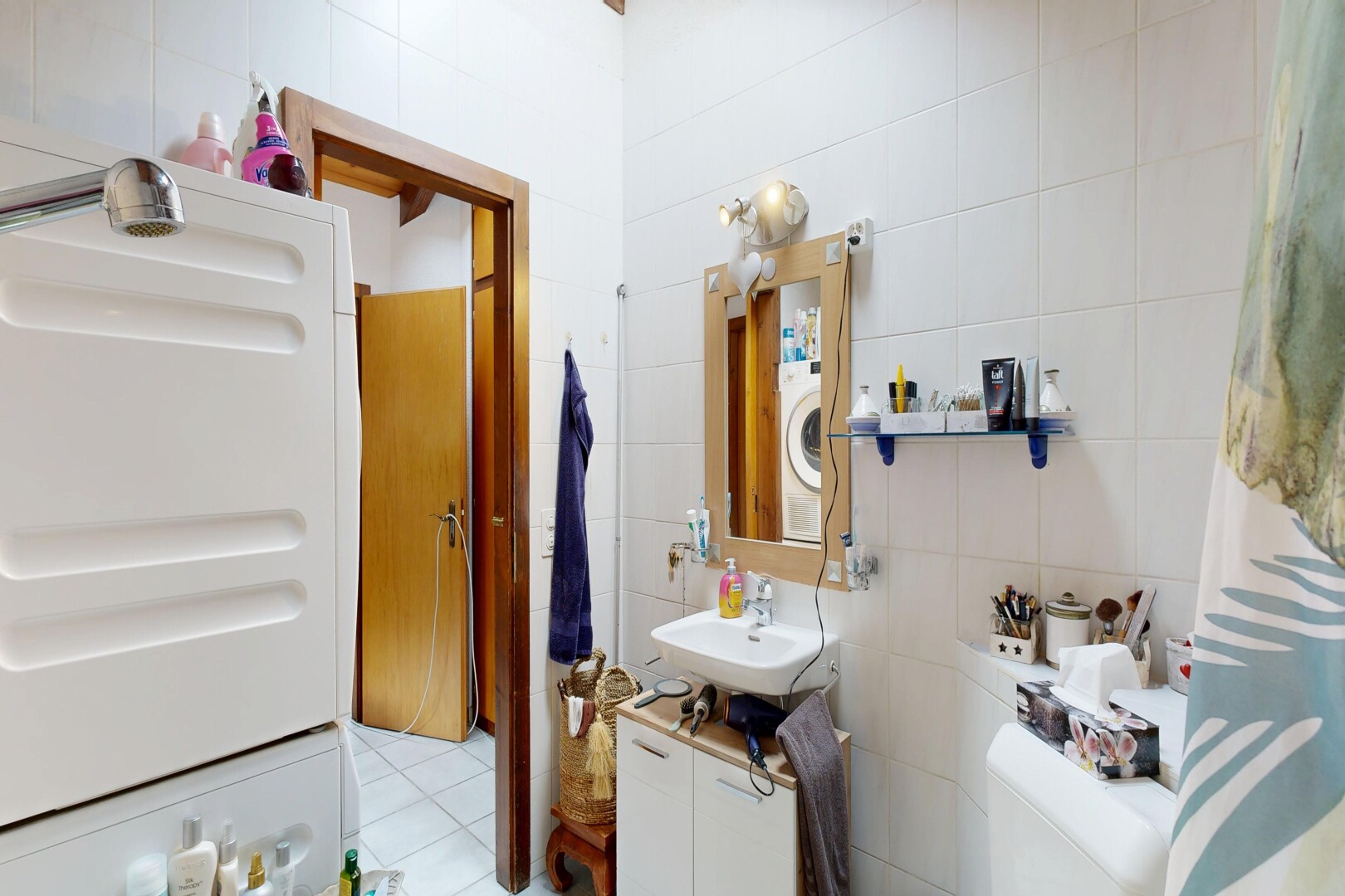 salle de bains avec tile wall, mur en carrelage, miroir, lavabo (ou coiffeuse selon le contexte), et évier