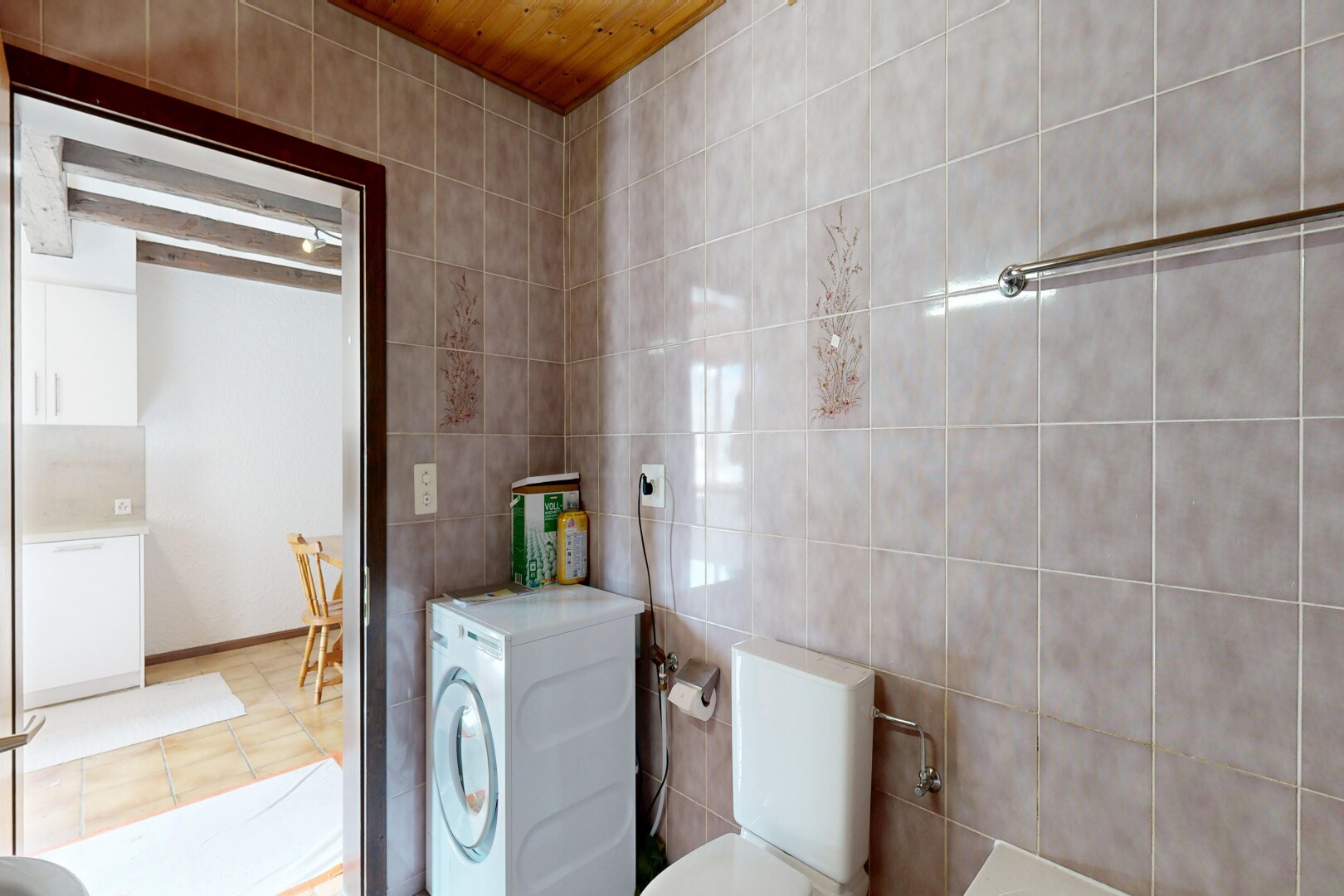 salle de bains avec mur en carrelage, tile wall, lave-linge et sèche-linge, toilette, et inside property