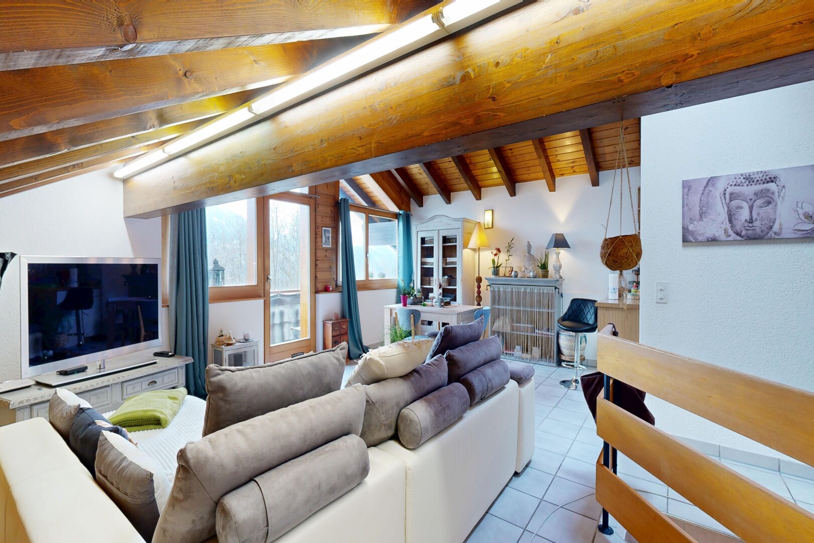 salon avec plafond voûté, vaulted ceiling, inside property, télévision, et lumière naturelle