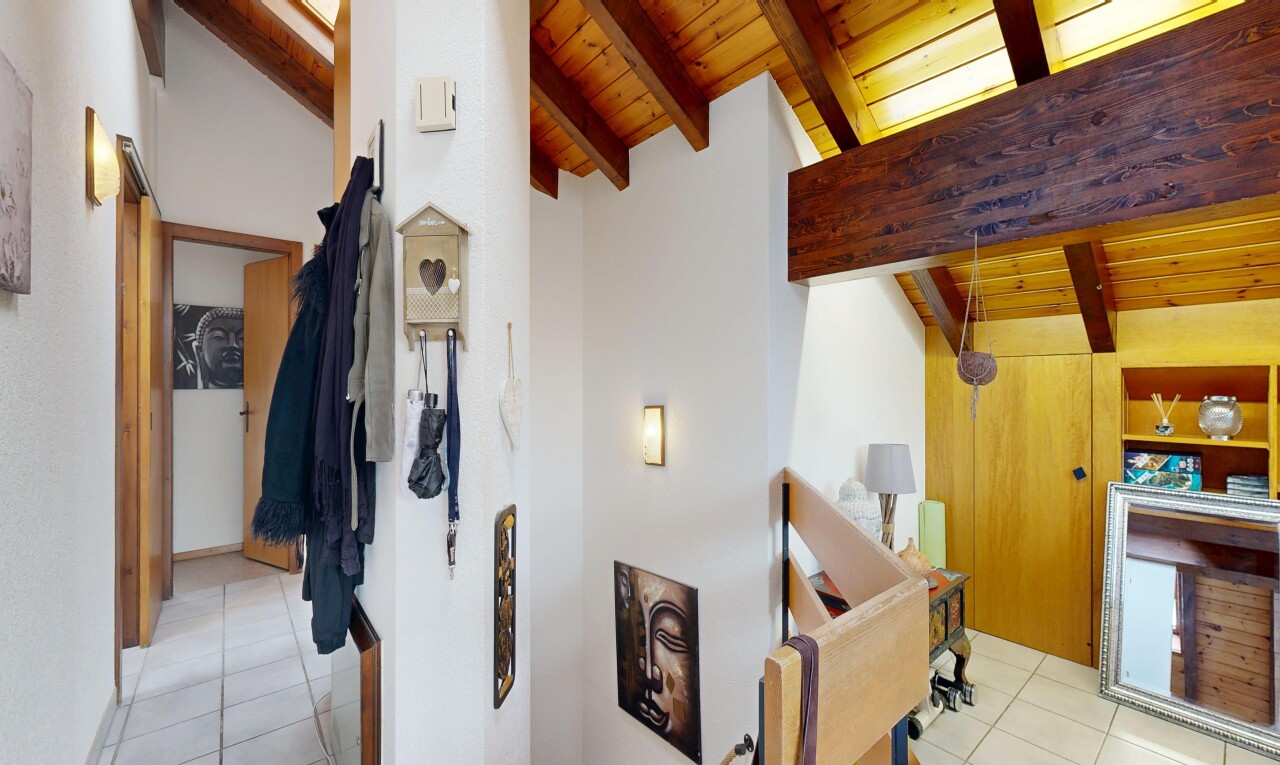 couloir avec tile floor, sol en carrelage, light floor, inside property, et vaulted ceiling