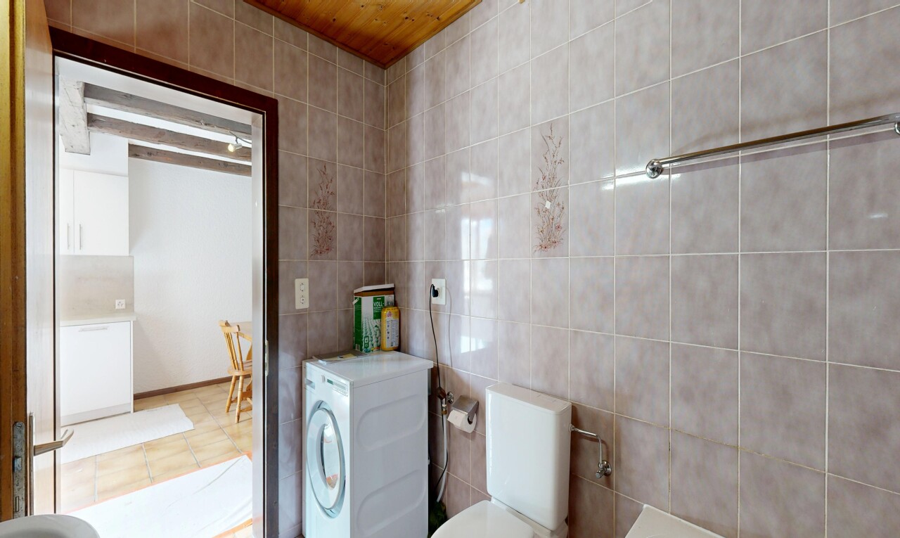 salle de bains avec mur en carrelage, tile wall, lave-linge et sèche-linge, toilette, et inside property