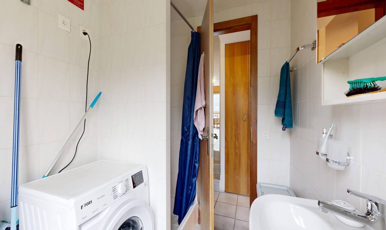 salle de bains avec lave-linge et sèche-linge, tile wall, mur en carrelage, douche, et salle de bain complète