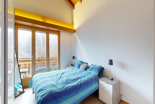 chambre avec natural light, lumière naturelle, inside property, accès à l'extérieur, et wood finish floor