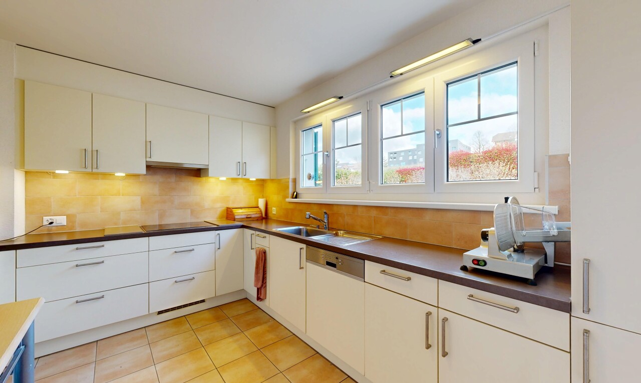 cuisine avec dark countertops, plans de travail, light floor, backsplash, et dosseret