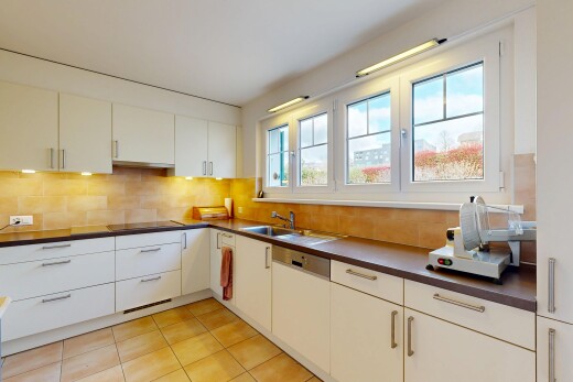 cuisine avec dark countertops, plans de travail, light floor, backsplash, et dosseret
