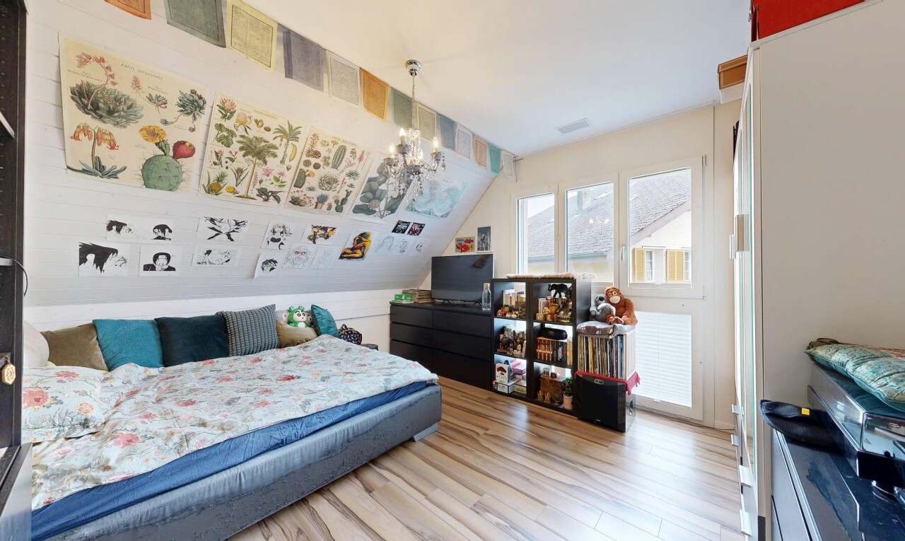 zimmer / schlafzimmer mit inside property, fernseher, holzfußboden, wood finish floor, und bemerkenswerter kronleuchter