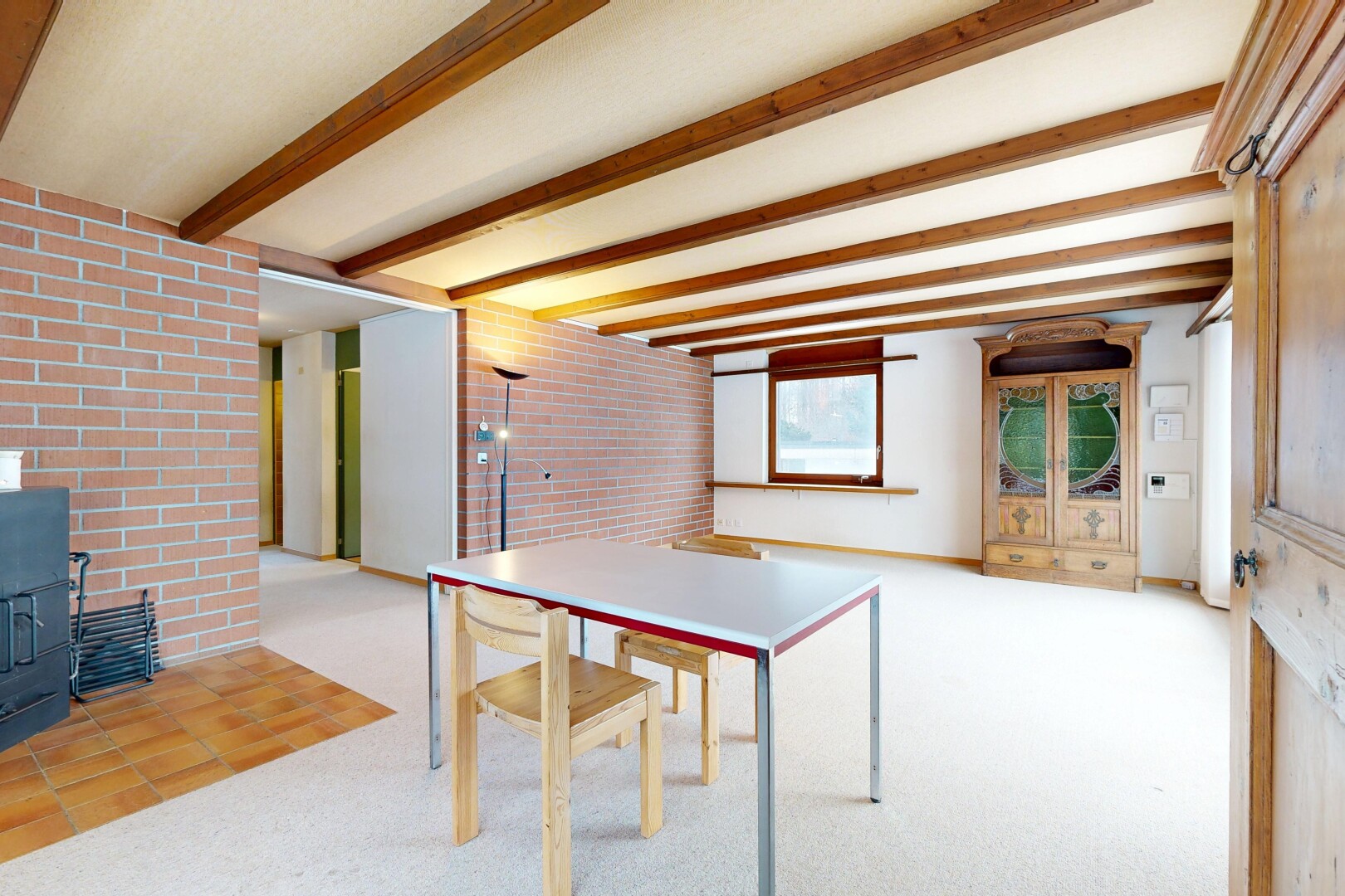 salle à manger avec mur en brique, brick wall, plafond à poutres, beamed ceiling, et lumière naturelle