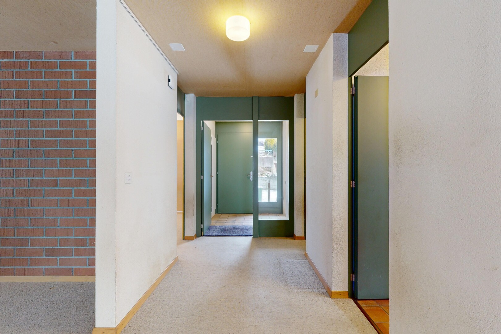 couloir avec inside property, mur en brique, brick wall, plinthes murales, et baseboards wall