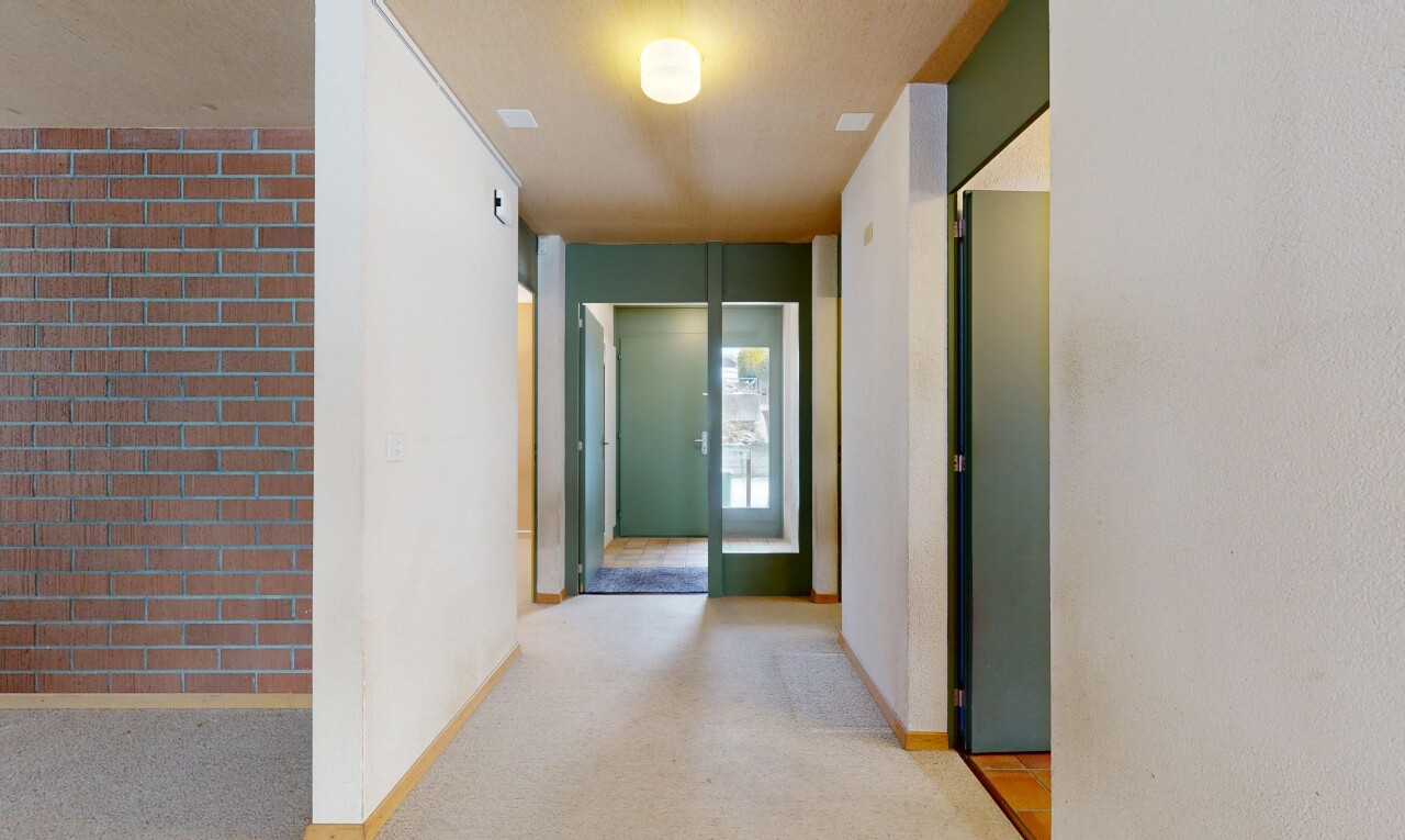 couloir avec inside property, mur en brique, brick wall, plinthes murales, et baseboards wall