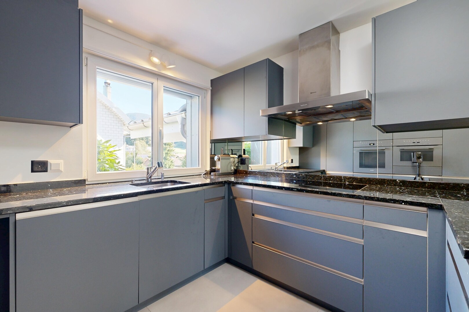 küche mit dunstabzugshaube, dark countertops, gray cabinets, graue schränke, und light floor