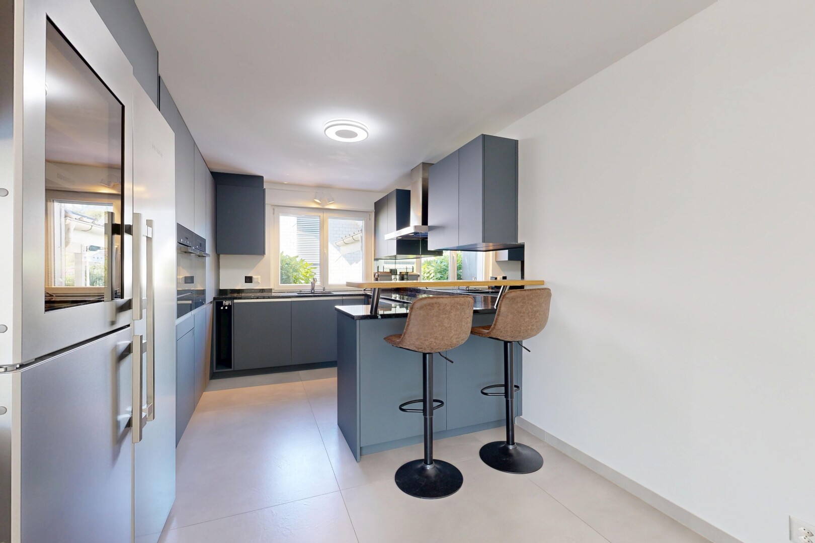 küche mit kühlschrank, light floor, arbeitsplatten, dark countertops, und küchenbar