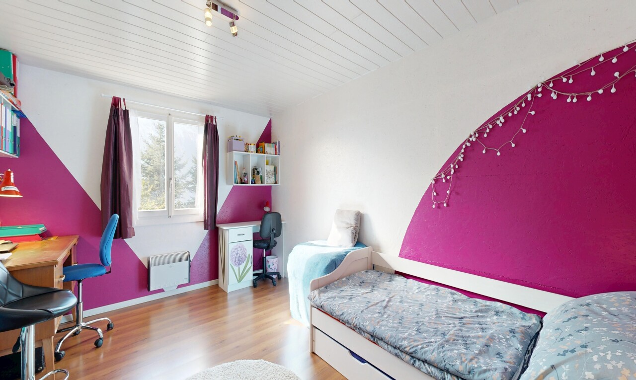 chambre avec cloison sèche, drywall, sol en finition bois, wood finish floor, et lumière naturelle