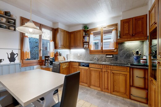 cuisine avec armoires marron moyen, medium brown cabinets, étagères ouvertes, open shelves, et éclairage suspendu