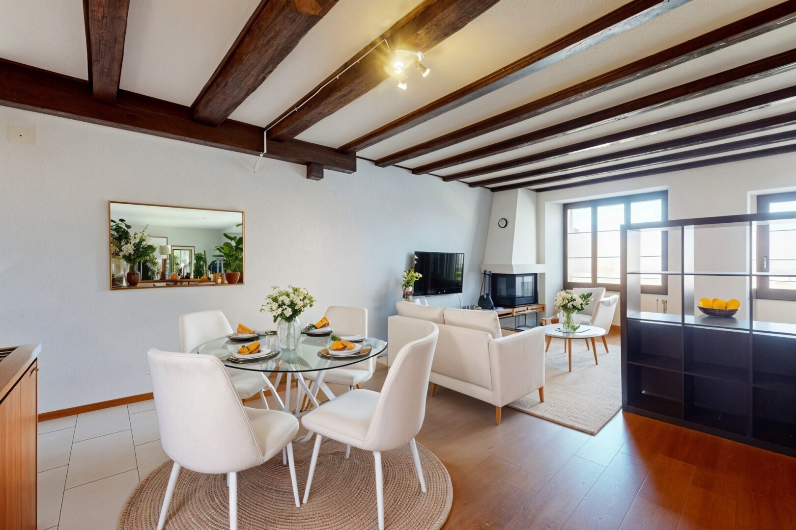 salon / salle à manger avec cloison sèche, lumière naturelle, plafond à poutres, et télévision