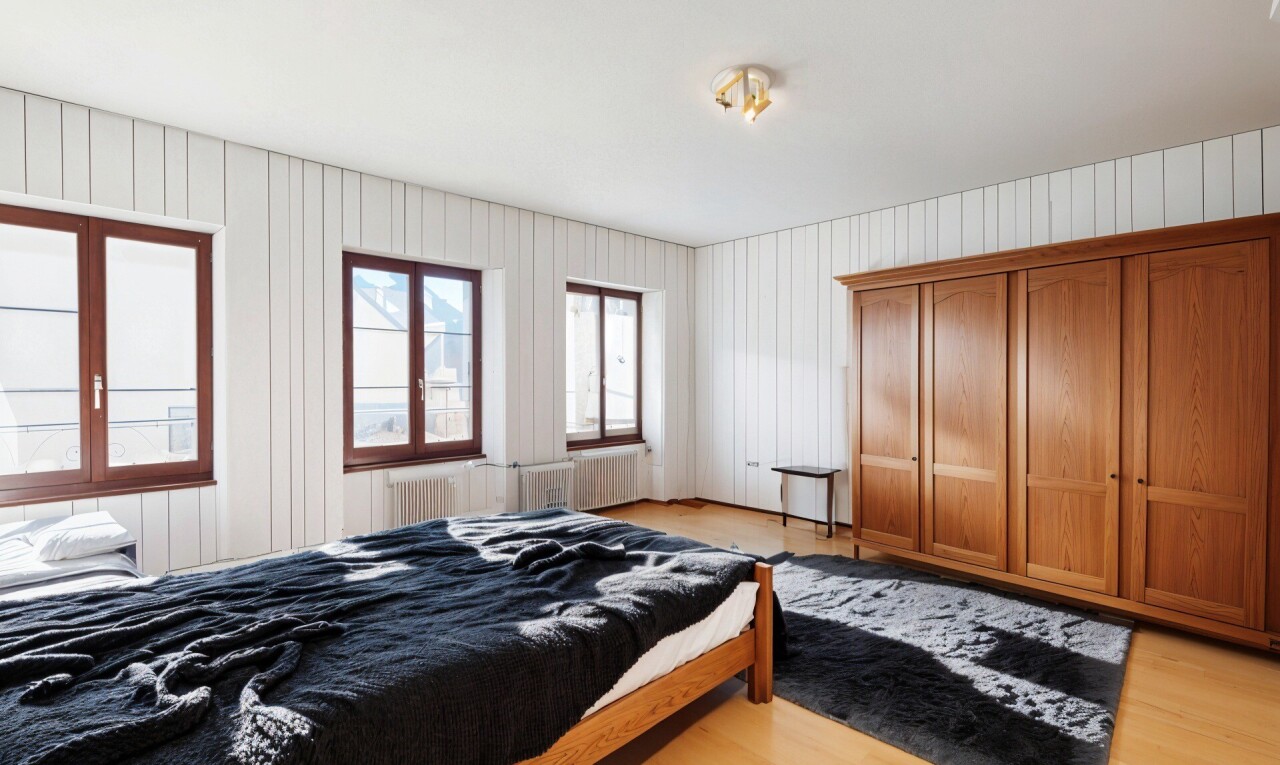 chambre avec lumière naturelle et sol en finition bois