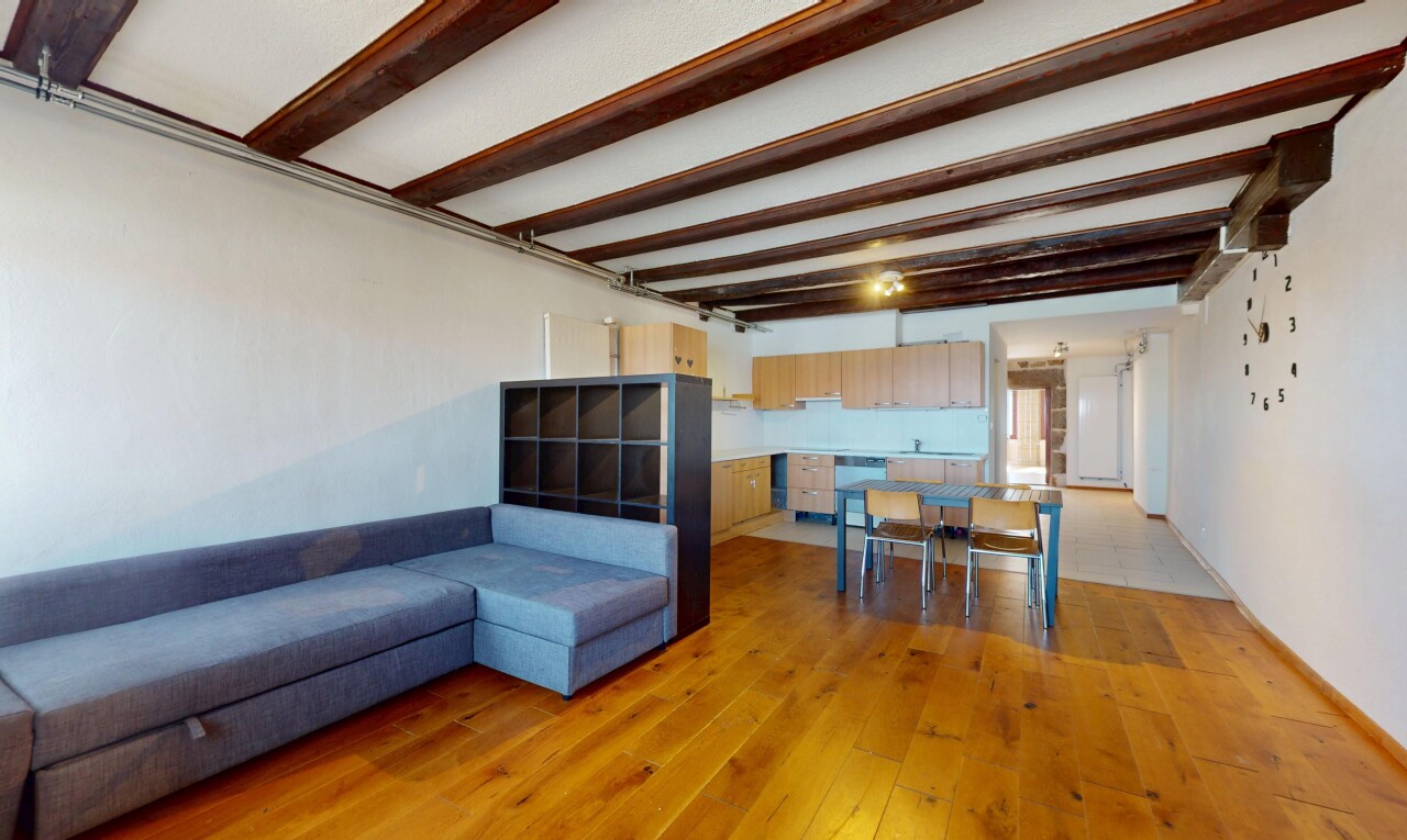 salon / salle à manger avec cloison sèche, sol en finition bois, et plafond à poutres