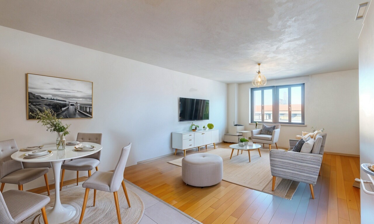 salon / salle à manger avec lumière naturelle, télévision, cloison sèche, et sol en finition bois