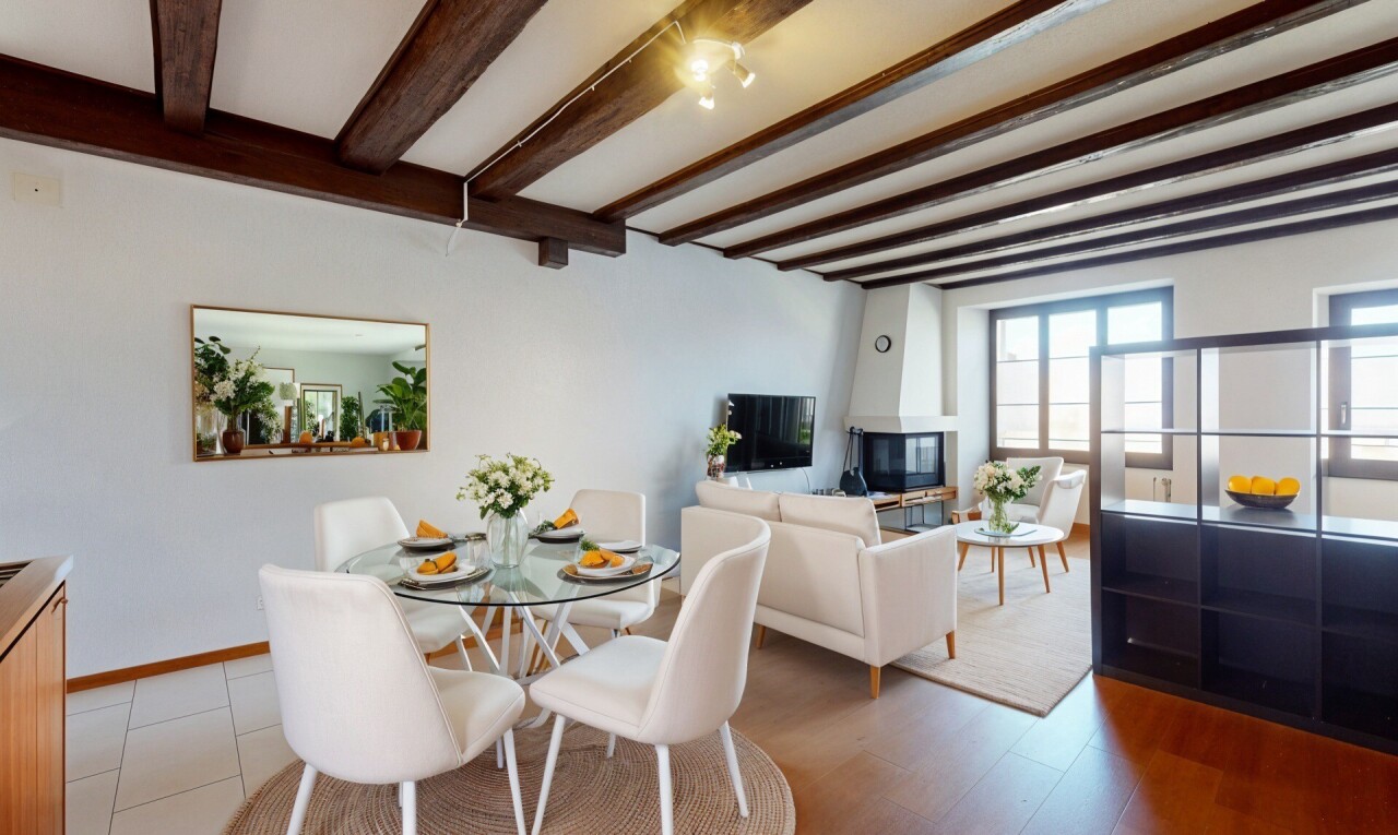salon / salle à manger avec cloison sèche, lumière naturelle, plafond à poutres, et télévision