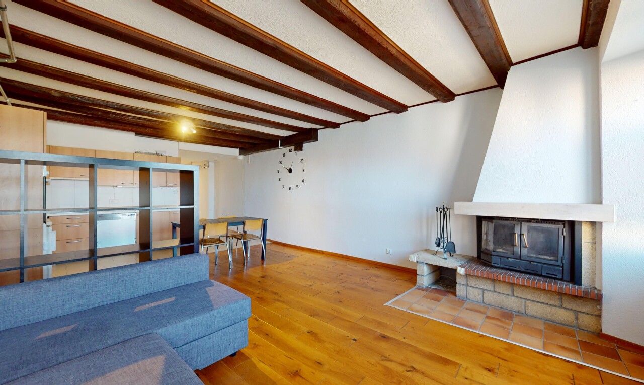 salon / salle à manger avec cloison sèche, plafond à poutres, sol en finition bois, et plinthes murales