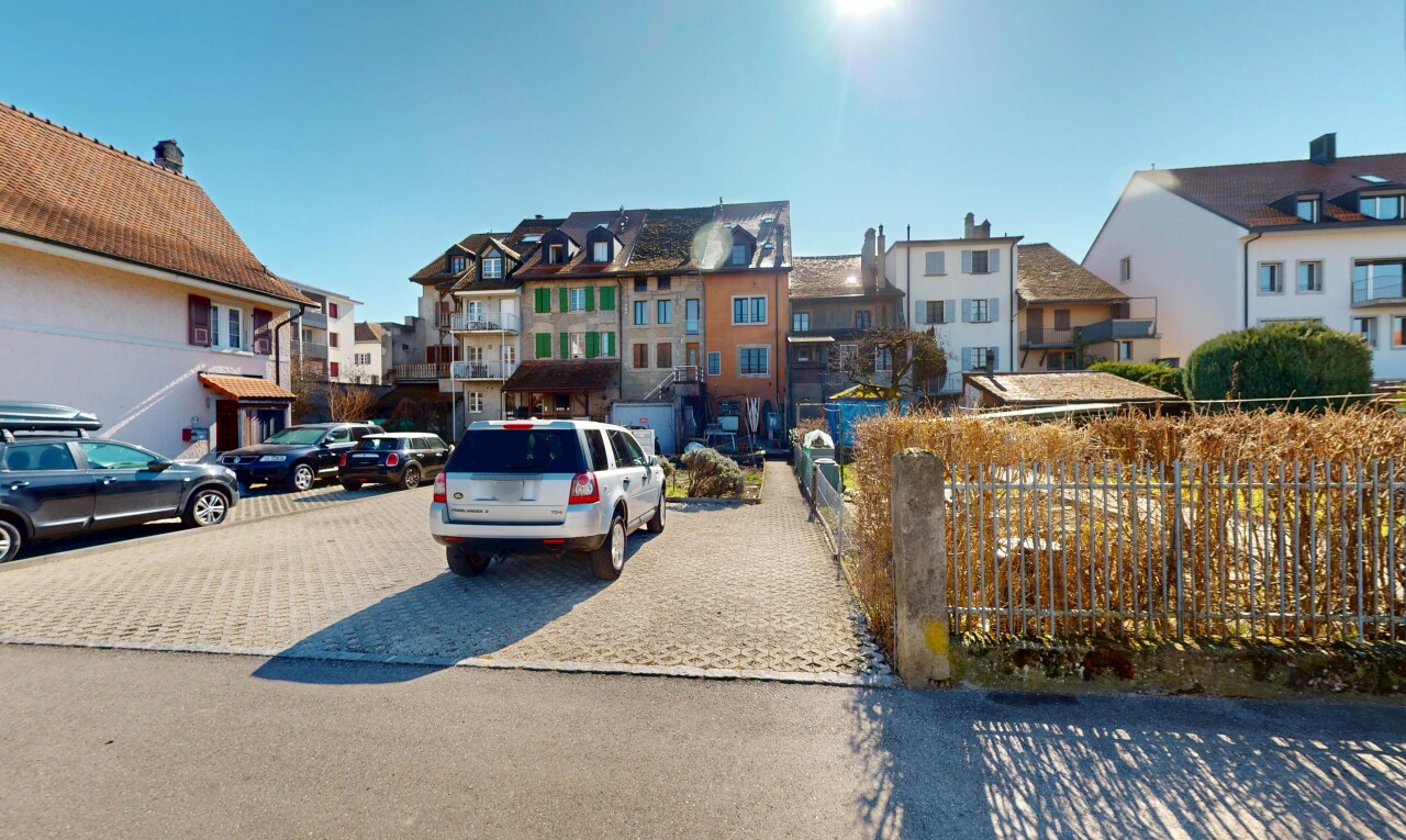 extérieur du bâtiment avec clôture, vue résidentielle, et aire de stationnement