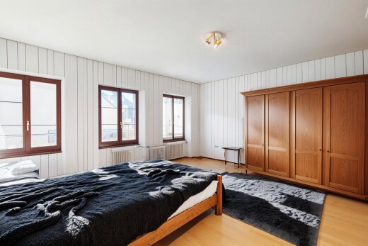 chambre avec lumière naturelle et sol en finition bois