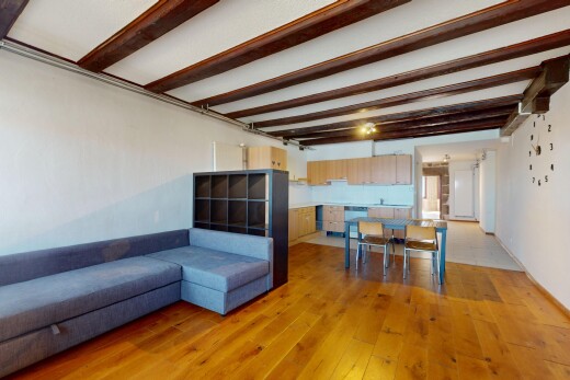 salon / salle à manger avec cloison sèche, sol en finition bois, et plafond à poutres