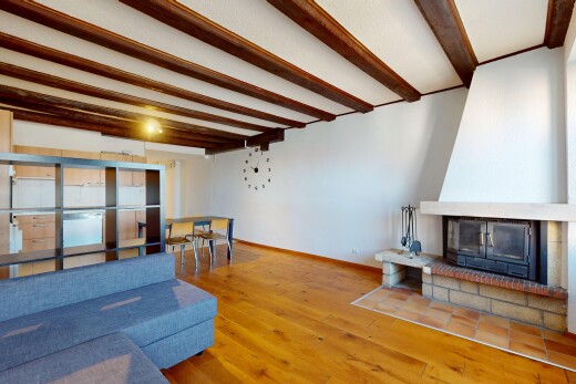 salon / salle à manger avec cloison sèche, plafond à poutres, sol en finition bois, et plinthes murales