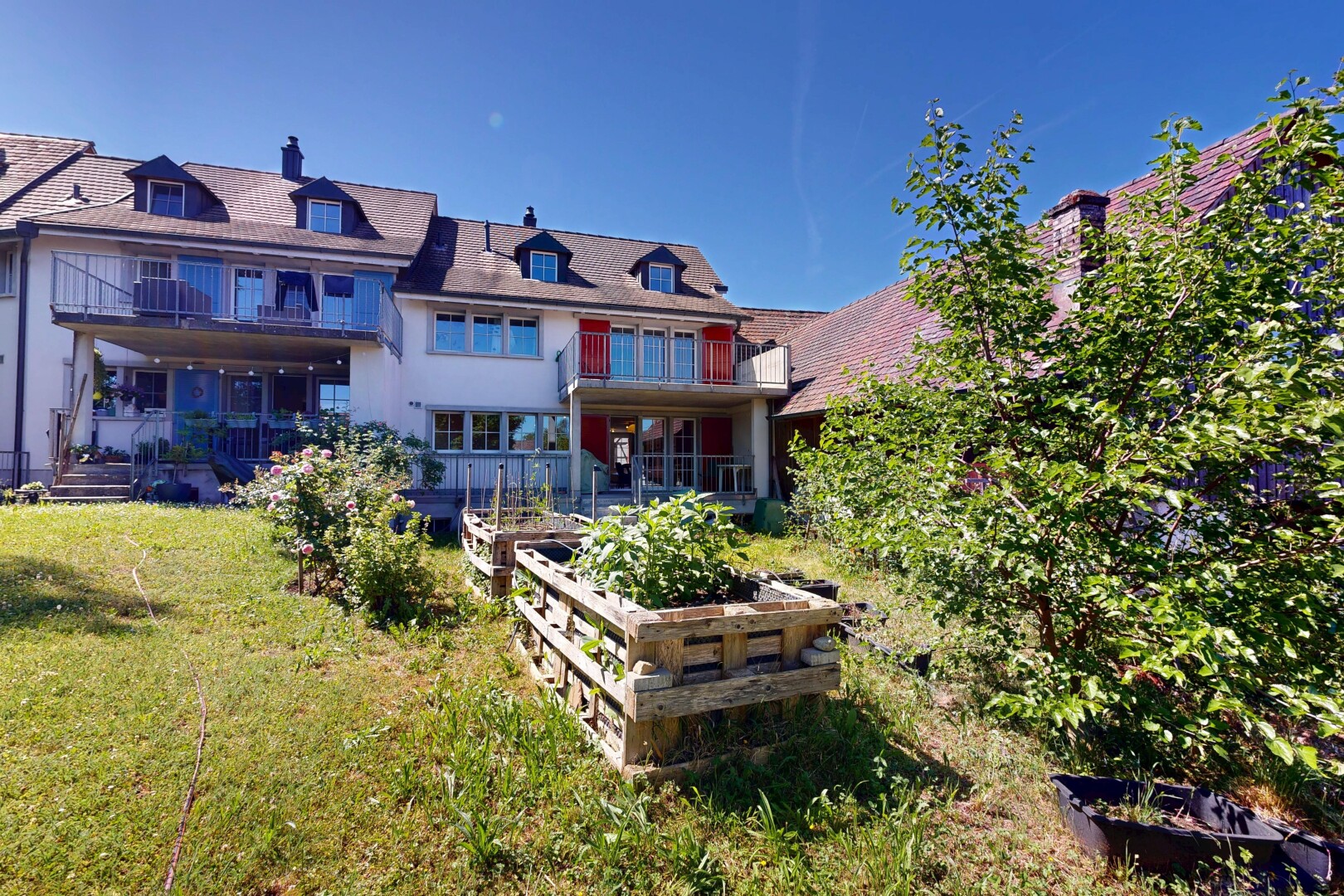 façade avec toit mansardé, balcon, pelouse, jardin, et day time