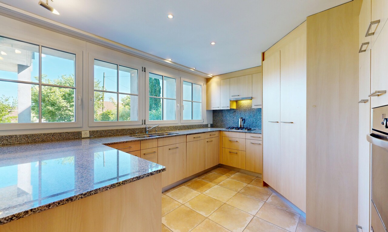cuisine avec stone countertops, plans de travail en pierre, light floor, light brown cabinets, et armoires marron clair
