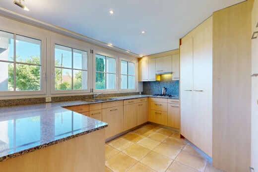 cuisine avec stone countertops, plans de travail en pierre, light floor, light brown cabinets, et armoires marron clair