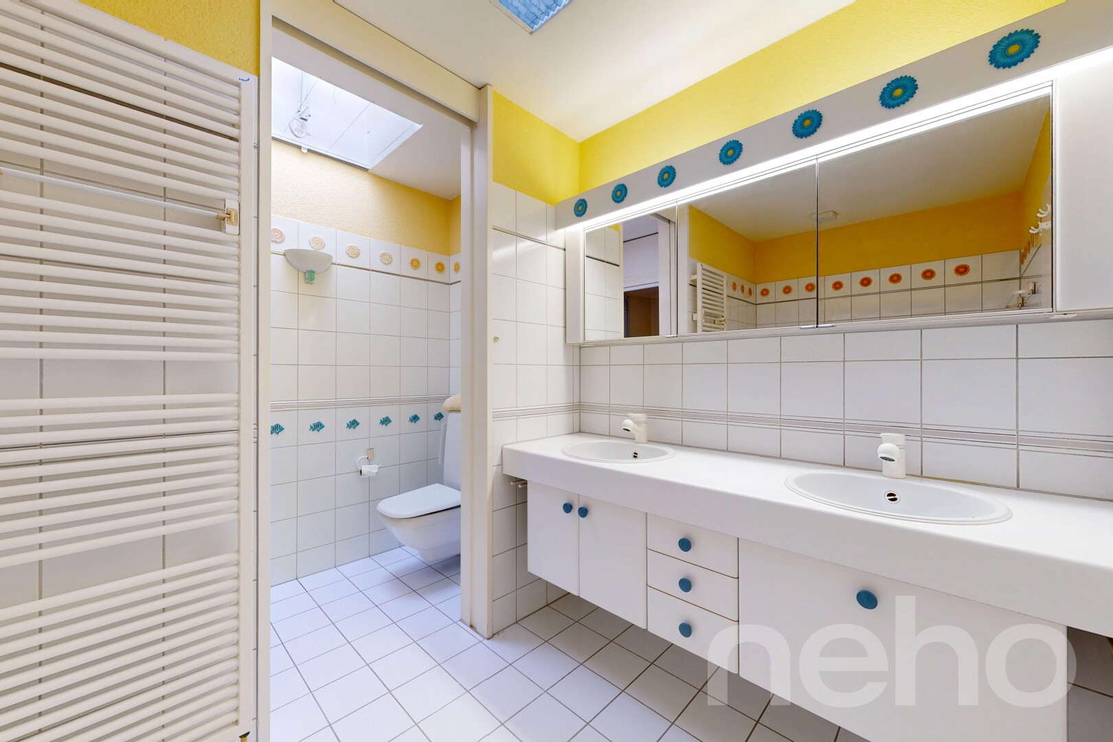 salle de bains avec radiateur, double vasque, puits de lumière, inside property, et mur en carrelage