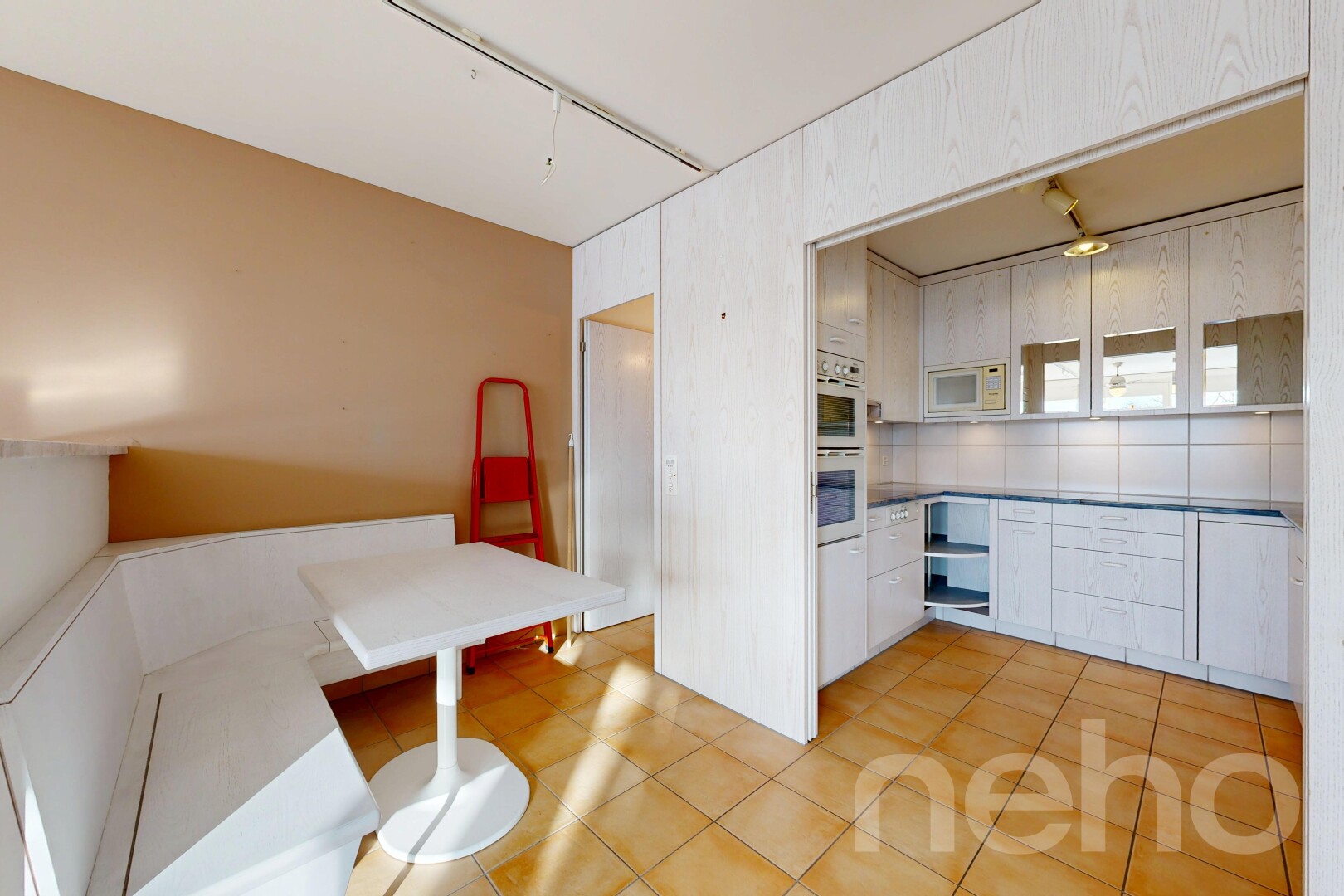 cuisine avec inside property, sol en carrelage, tile floor, micro-ondes, et armoires blanches